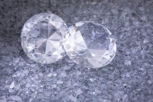 Två stora slipade diamanter som vilar på en bädd av små krossade kristaller.