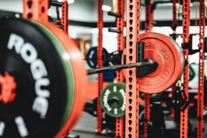 Röd skivstångsställning med tunga viktskivor i ett professionellt gym.